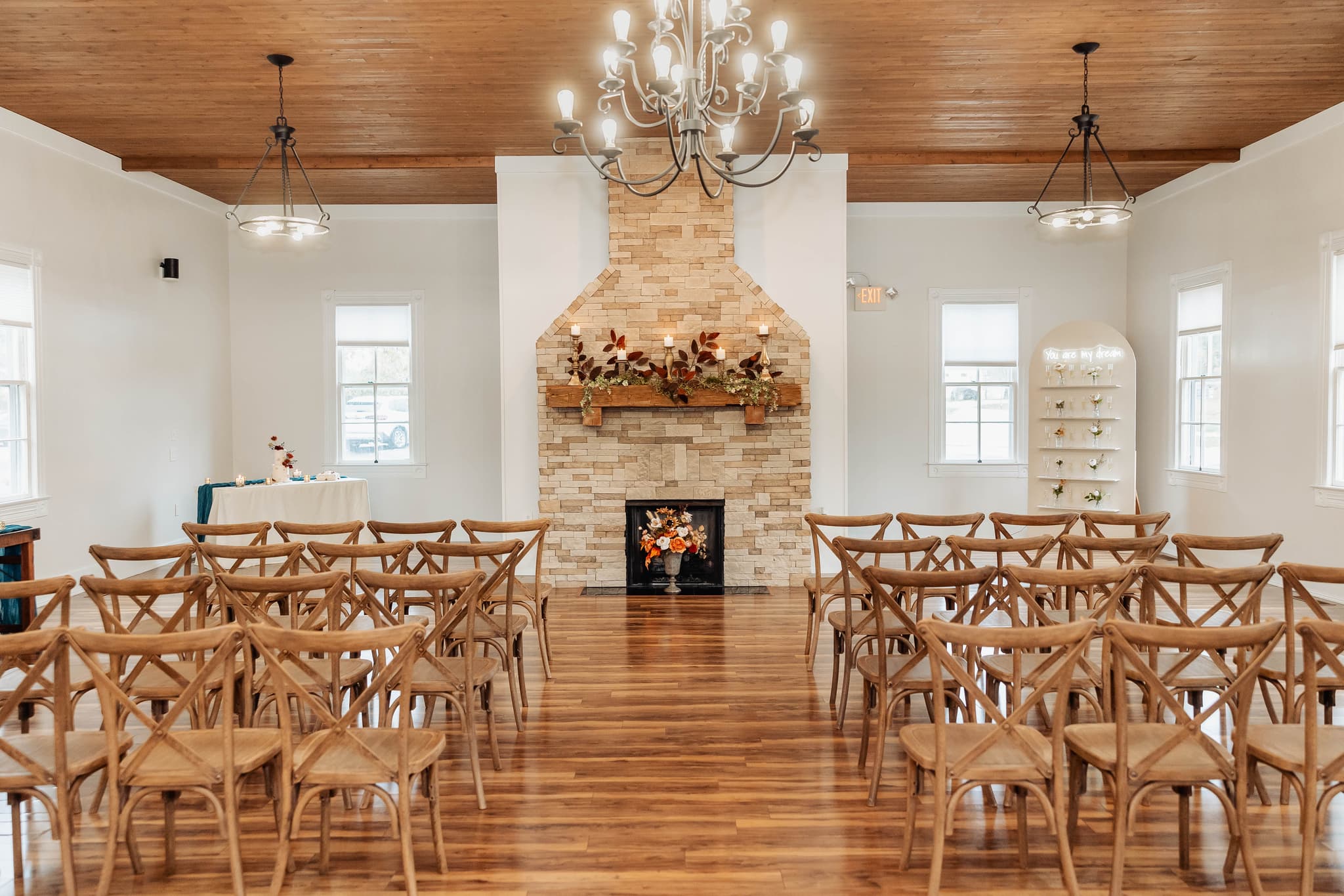 An inside view of the 1860 Schulhaus showcasing their wooden floors, ambient lighting, brick fireplace, ornate chandeliers. Stl wedding venues