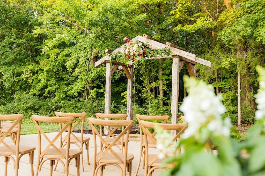 Outdoor wedding setting with trellis and chairs set up.