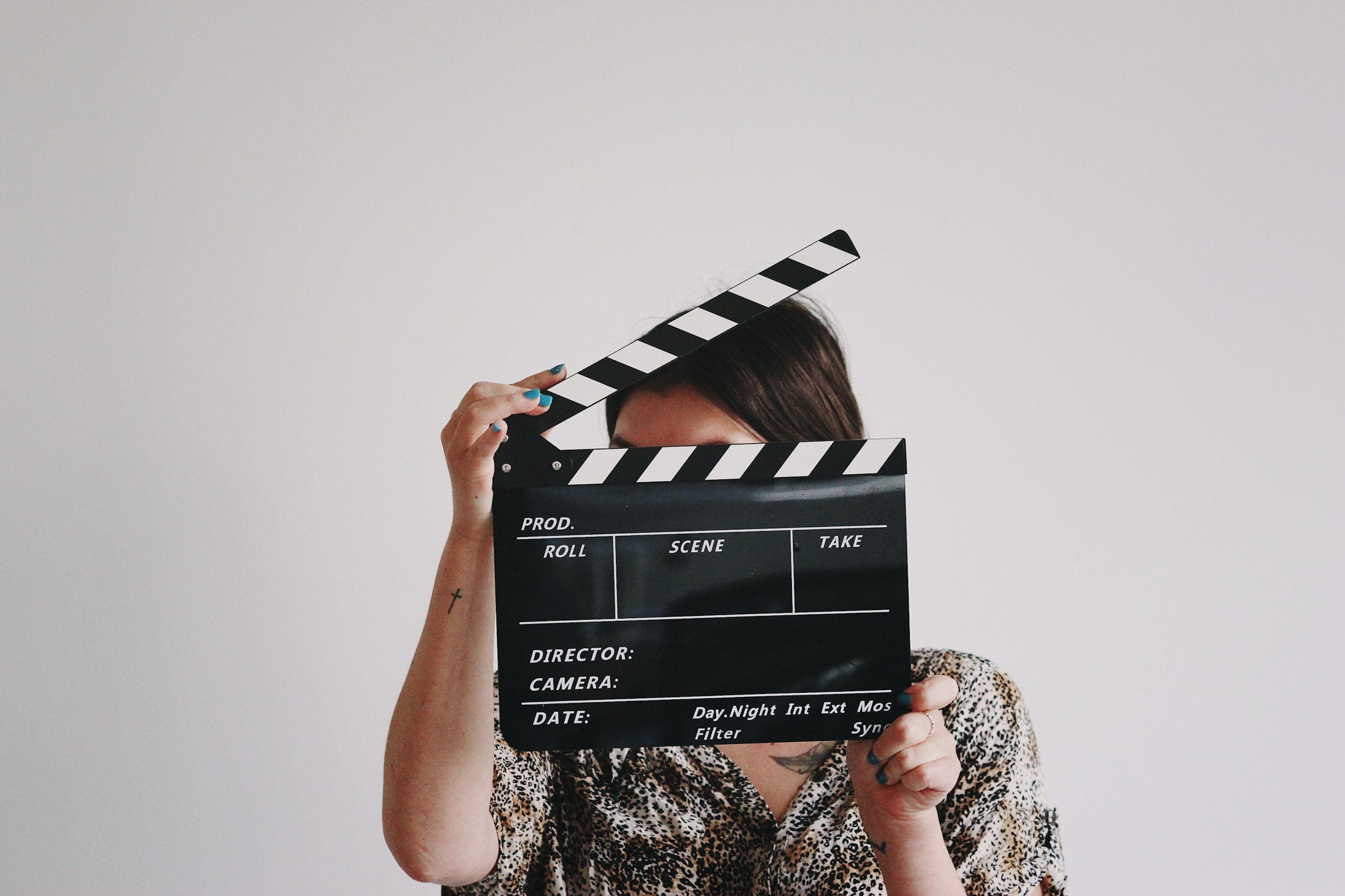 a woman holding a movie clapper board