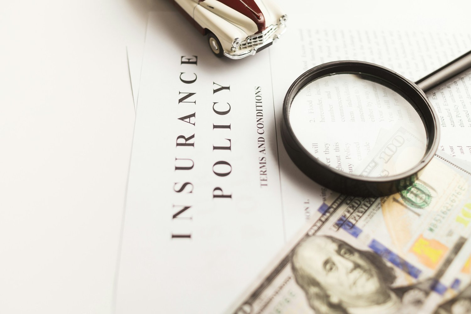 a magnifying glass next to a car and money